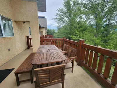 a wooden table and chairs on a balcony at Riverside Way by Fernie Lodging Company in Fernie