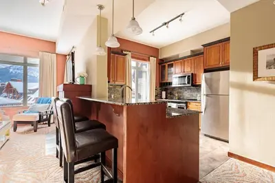 a kitchen with wooden cabinets and a counter with a sink at Sun Drenched Escape - 50 Percent Off Apr - May in Canmore