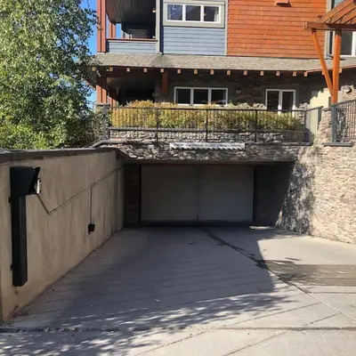 a parking lot in front of a house with a garage at Mountain Luxe - 50 Percent Off April & May in Canmore