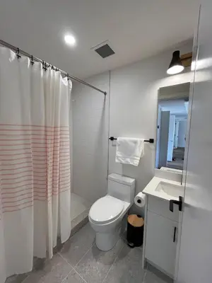 a bathroom with a toilet and a shower and a sink at Top FL 2BR 2BA Hot Tubs phenomenal mountain views in Canmore