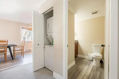 a bathroom with a toilet and a dining room at Gondola Heights by Outpost Whistler in Whistler