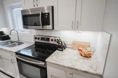 a kitchen with a stove and a bowl of oranges at DOWNTOWN KINGBED 4Br FIREPLACE BIKELANE in Edmonton