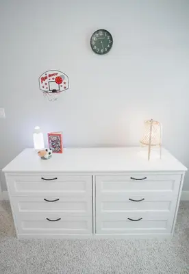 a white dresser in a room with a white wall at DOWNTOWN KINGBED 4Br FIREPLACE BIKELANE in Edmonton