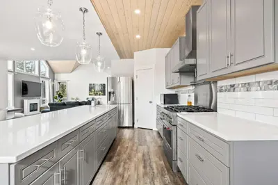 a kitchen with white cabinets and a wooden ceiling at Radiant Retreat -Spacious Home - Heart of Radium! in Radium Hot Springs