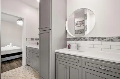a white bathroom with a sink and a mirror at Radiant Retreat -Spacious Home - Heart of Radium! in Radium Hot Springs