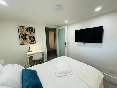 a bedroom with a bed and a flat screen tv at Quiet Basement Suite Steps from Quilchena Park in Vancouver in Vancouver