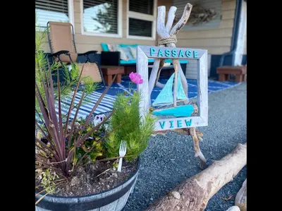 a garden with a sign that says passage and a view at Passage view in Campbell River