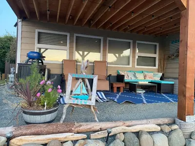 a house with a patio with a table and a chair at Passage view in Campbell River