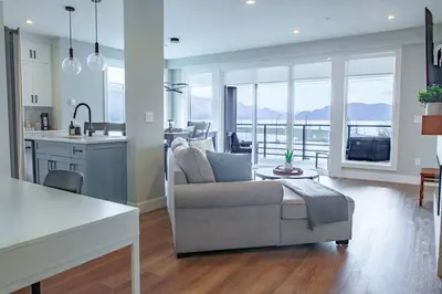 a living room with a couch and a kitchen at 2 Bedroom with Lake and Mtn Views in Harrison Hot Springs