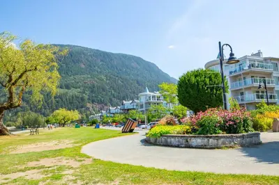 a park with buildings and a mountain in the background at 2 Bedroom with Lake and Mtn Views in Harrison Hot Springs