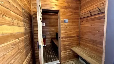 a sauna with wooden walls and a wooden door at Mountain Edge Resort Inn by StayIn in Kimberley
