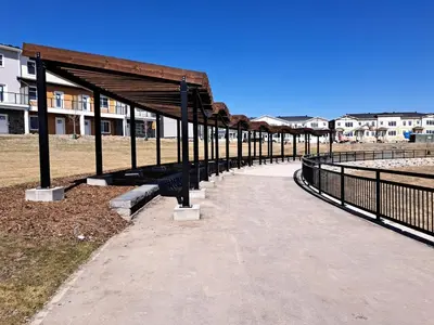 a walkway next to a building with a fence at Cozy 2 Bedroom Walkout Basement in Calgary