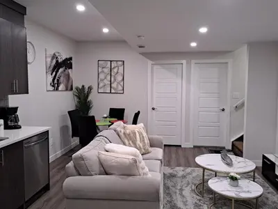a living room with a couch and a table at Cozy 2 Bedroom Walkout Basement in Calgary