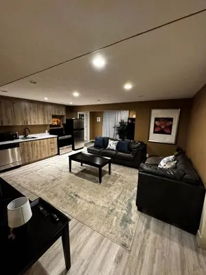 a large living room with couches and a kitchen at Cozy and Spacious Basement in Chestermere