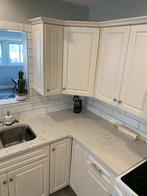 a white kitchen with white cabinets and a sink at Spacious Drumheller-RetreatMuseum & Golf in Drumheller