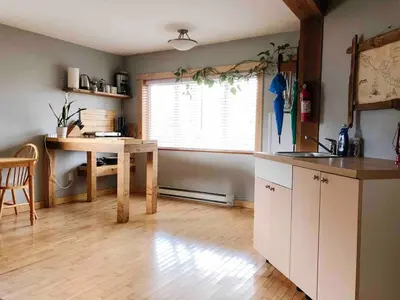 a kitchen with a table and a window in it at Coastal Suite - Harbourview in Ucluelet in Ucluelet