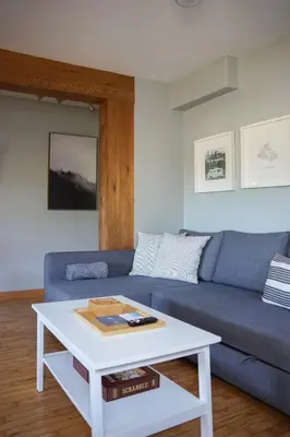 a living room with a blue couch and a white coffee table at Coastal Suite - Harbourview in Ucluelet in Ucluelet