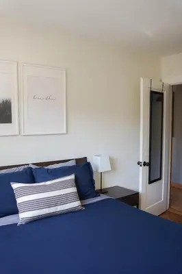a bedroom with a blue bed with blue pillows at Coastal Suite - Harbourview in Ucluelet in Ucluelet
