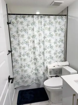 a bathroom with a toilet and a shower curtain at Charming Basement Suite in Edmonton