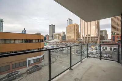 a view of a city from the balcony of a building at Stylish Condo with Exclusive Rooftop Pool in Calgary