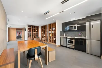 a kitchen with a wooden table and a refrigerator at Stylish Condo with Exclusive Rooftop Pool in Calgary