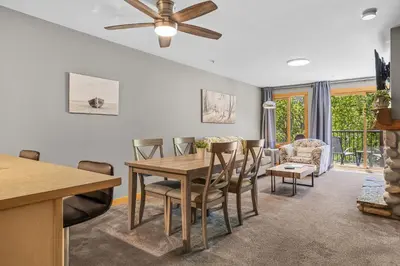 a living room with a dining room table and chairs at Creekside Downtown 2 Bedroom Condo managed by Little Sister Getaways in Canmore