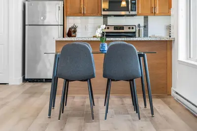 two chairs sitting at a kitchen table with a refrigerator at Luxury Lake View Condo in West Kelowna, 5 Star Resort with Pool, Hot Tub and Gym in West Kelowna