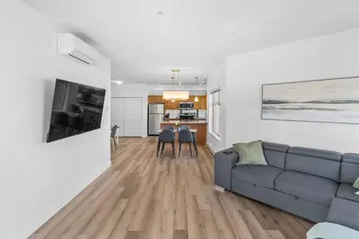 a living room with a couch and a kitchen at Luxury Lake View Condo in West Kelowna, 5 Star Resort with Pool, Hot Tub and Gym in West Kelowna