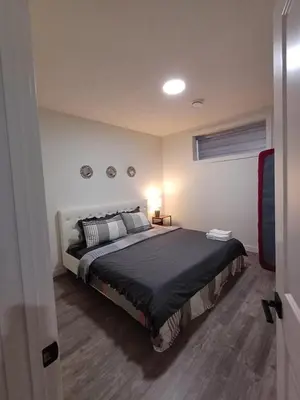 a bedroom with a large bed in a room at Haven Lodge, 2BR Brand New Basement Suite in Calgary