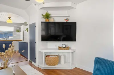 a living room with a tv on a white wall at Bluebird 3 Bedroom Home in the Heart of Drumheller in Drumheller