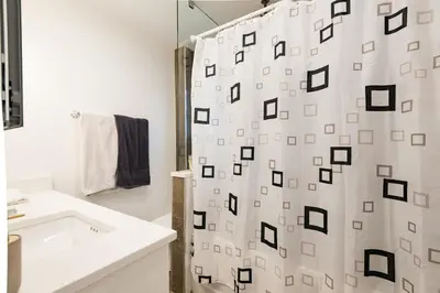 a bathroom with a shower curtain and a sink at Beautiful Vancouver Cedar Cottage House in Vancouver