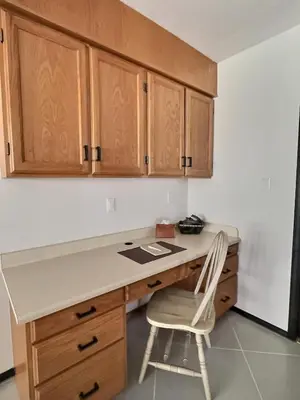 a kitchen with a desk and a white chair at Vineyard Home Casa De Herrera in Keremeos