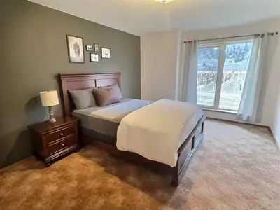 a bedroom with a large bed and a window at Vineyard Home Casa De Herrera in Keremeos