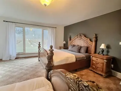 a bedroom with a large bed and a window at Vineyard Home Casa De Herrera in Keremeos