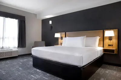 a hotel room with a large bed and a window at Canalta Cochrane in Cochrane