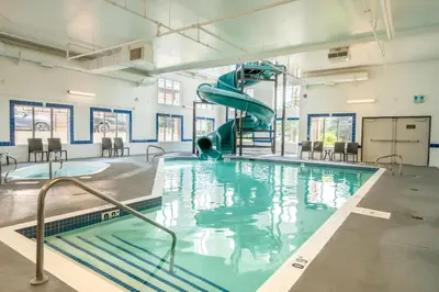 a swimming pool with a slide in a building at Canalta Cochrane in Cochrane