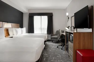 a hotel room with two beds and a flat screen tv at Canalta Cochrane in Cochrane