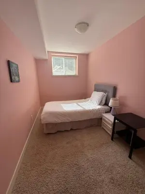 a small bedroom with a bed and a table at 2 bedroom Suite with private entrance in Langley
