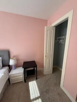 a bedroom with a bed and a table and a door at 2 bedroom Suite with private entrance in Langley