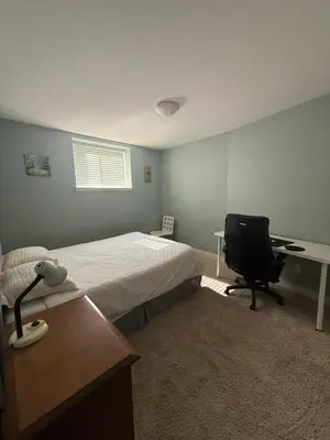 a bedroom with a bed and a desk and a chair at 2 bedroom Suite with private entrance in Langley