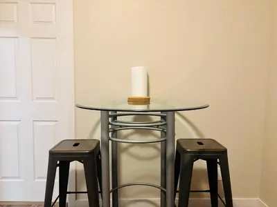 a table with two stools with a candle on top at Main Floor 1 Bedroom Suite with Parking in Calgary