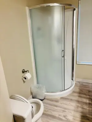 a bathroom with a shower and a white toilet at Upper Floor 1 Bedroom Suite with Parking in Calgary