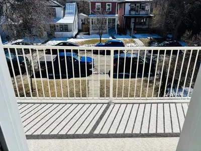 a white fence on a porch with snow on the ground at Upper Floor 1 Bedroom Suite with Parking in Calgary