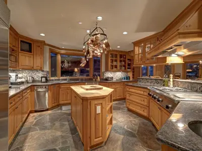 a large kitchen with wooden cabinets and a chandelier at Hapala Chalet in Whistler