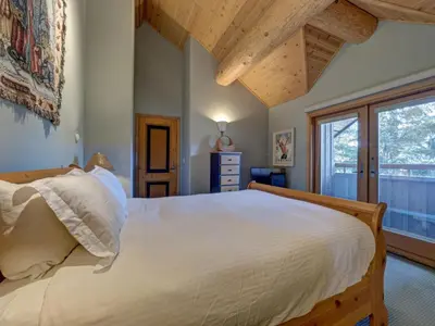 a bedroom with a large bed and a window at Hapala Chalet in Whistler