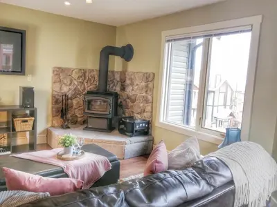 a living room with a couch and a wood stove at Relaxing Mountain View Condo in Beautiful Radium in Radium Hot Springs