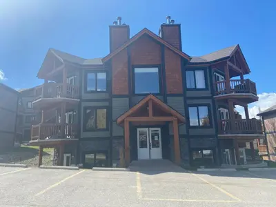 a large brick building with a white door in a parking lot at Relaxing Mountain View Condo in Beautiful Radium in Radium Hot Springs