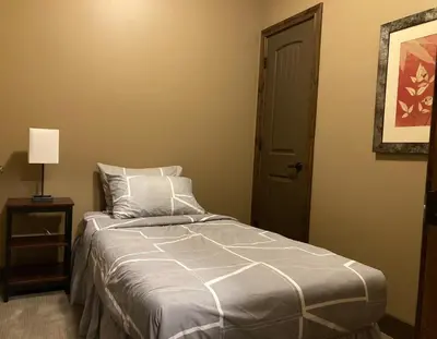 a bedroom with a bed with a night stand and a door at Mountain View Retreat in Radium Hot Springs