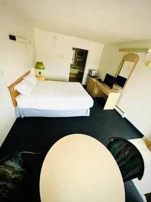 a hotel room with a bed and a table at Silver crest lodge in Grande Prairie
