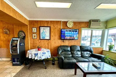 a living room with a leather couch and a table at Silver crest lodge in Grande Prairie